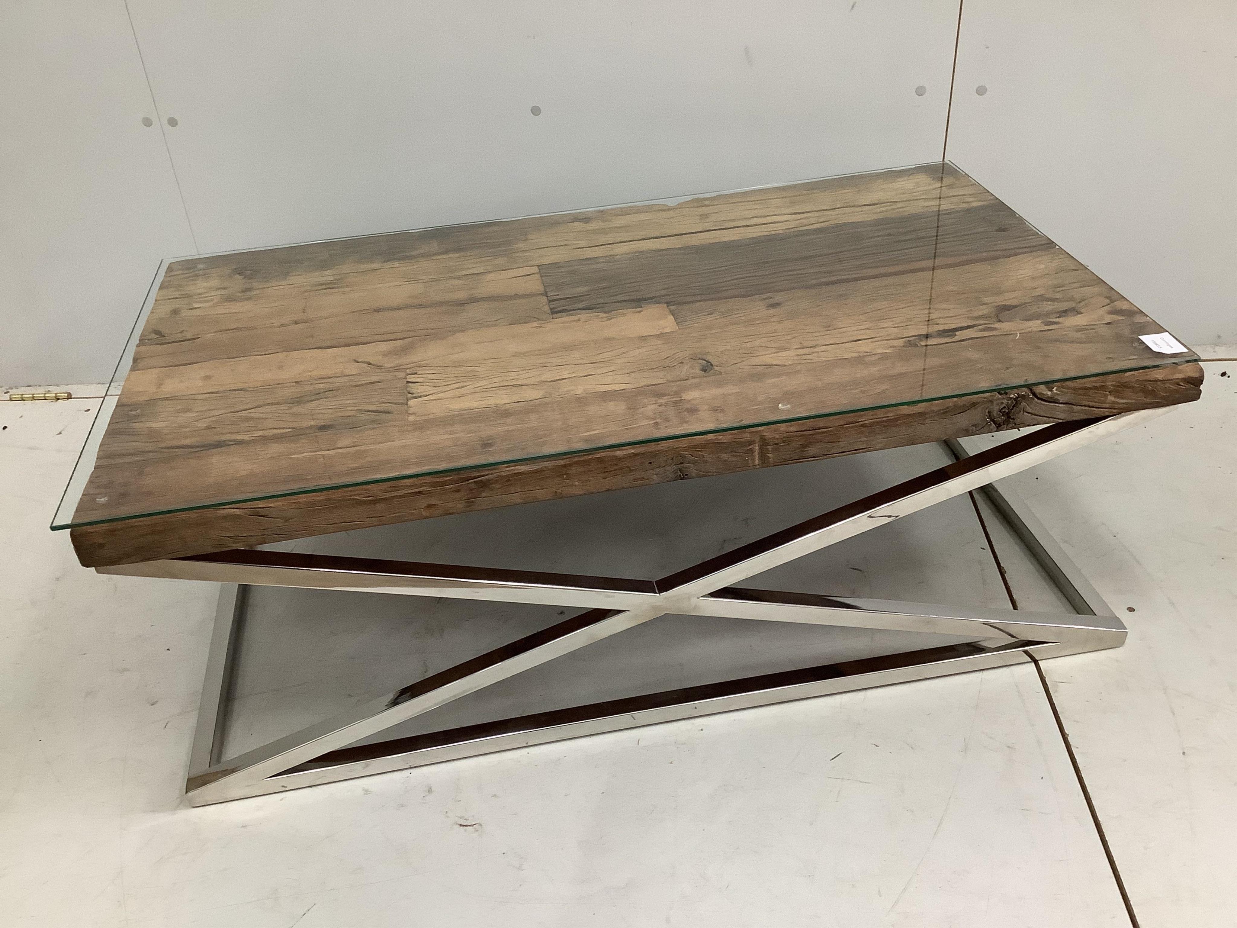 A Contemporary glass top weathered timber and chrome underframe coffee table, made from old train rail track woods, width 112cm, depth 61cm, height 40cm. Condition - good